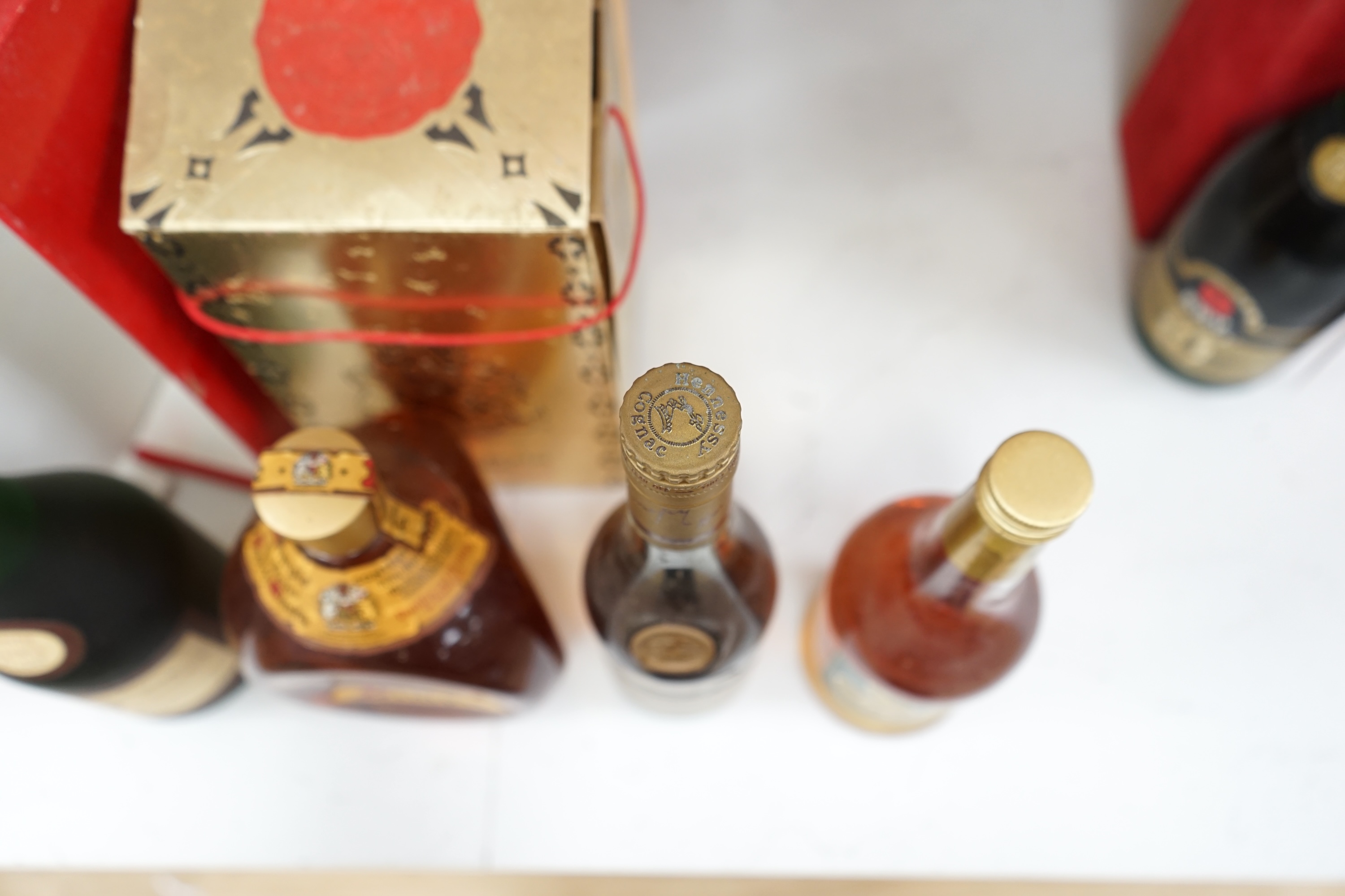 Four bottles of various alcohols comprising a bottle of 50cl Hennessey Fine Champagne Cognac, Planty Fine Cognac, Dimple Scotch Whisky and Glocken Apfel. Condition - fair, storage history unknown